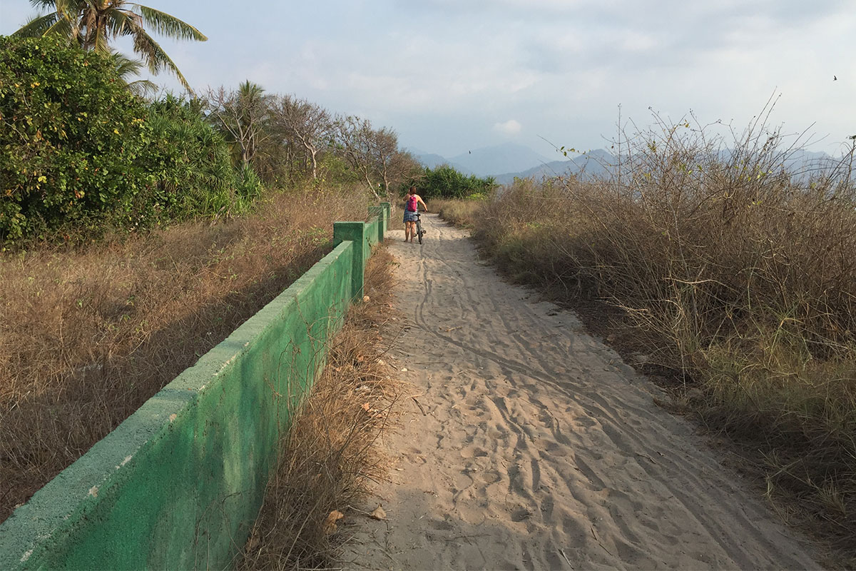 frau-fahrrad-sand-strasse-gili-air